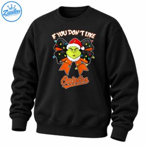Grumpy green character in a Santa hat with a black and orange bow, colorful Christmas lights, and Orioles lettering