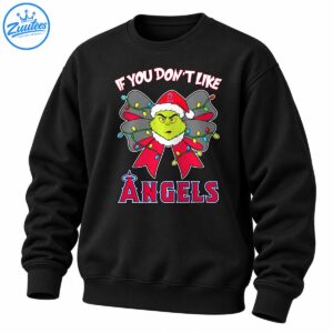 Grumpy green Christmas character in a Santa hat with a red and gray bow, colorful lights, and Angels lettering.