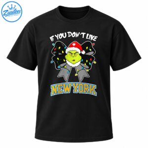 Grumpy green Christmas character in a Santa hat on a black light-covered bow with white text and bold New York lettering