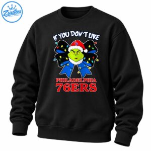 Grinch wearing a red Santa hat with a blue Christmas bow, colorful lights, and Philadelphia 76ers lettering