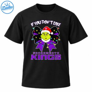 Grumpy green Christmas character in a Santa hat with a purple bow, colorful holiday lights, and Sacramento Kings lettering