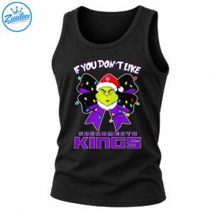 Grumpy green Christmas character in a Santa hat with a purple bow, colorful holiday lights, and Sacramento Kings lettering