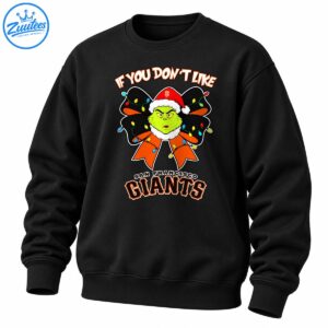 Grumpy green character in a red Santa hat with a black and orange Christmas bow, colorful lights, and San Francisco Giants lettering