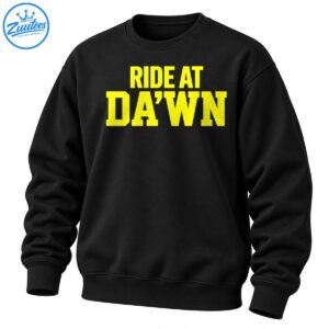 Bright yellow RIDE AT DA’WN collegiate lettering in two lines on a dark background