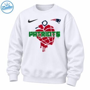 Red dripping grenade-like graphic with distressed green PATRIOTS lettering and navy and red sports-inspired emblems on a shirt.