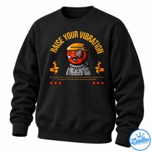 Raise Your Vibration shirt design with a cartoon character, golden lettering, orange flames, stars, and an uplifting quote.